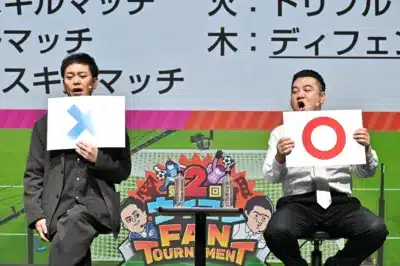 ステージ上でOとXの札を掲げる男性タレント