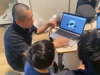 子どもに説明する男性とノートパソコン