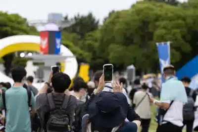 夜景の中、スマートフォンを掲げるトレーナーたち