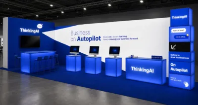 ThinkingAIのモダンな展示ブースです。青と白を基調とし、「Business on Autopilot」をテーマにAIによるビジネス自動化と成長を提案。複数のモニターやカウンターが配置されています。