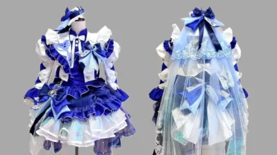 青と白を基調とした、フリルやリボン、レースがふんだんに使われた豪華な衣装がマネキンに飾られています。ファンタジー感のあるドレスで、前後のデザインが示されています。